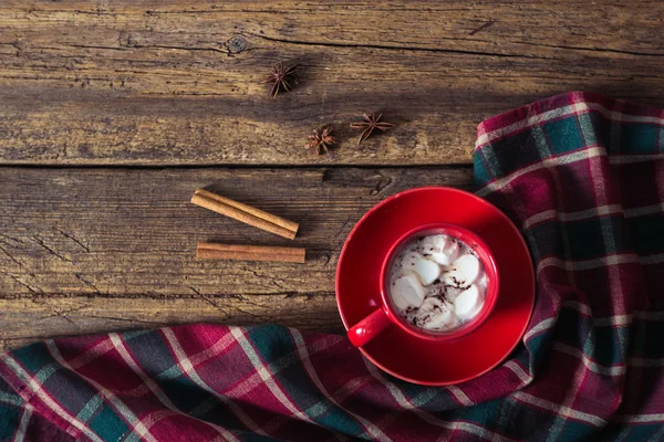 red cup with cocoa and marshmallows on wooden background