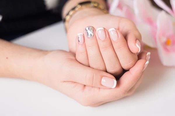 Mooie gel lak. Franse manicure met zilveren diamanten. Women's handen. — Stockfoto