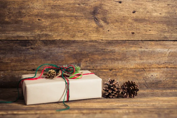 キャンデー杖、モミの枝、ろうそく、円錐形の木製の背景にクリスマス プレゼントします。. — ストック写真