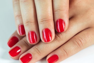 Manikür - güzel yumuşak beyaz havlu üzerinde kırmızı oje ile kadının elleri manikürlü