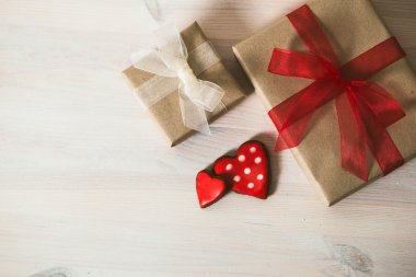 hediye kutusu beyaz ahşap bir masa üzerinde kırmızı kurdele ile. ev yapımı cooki