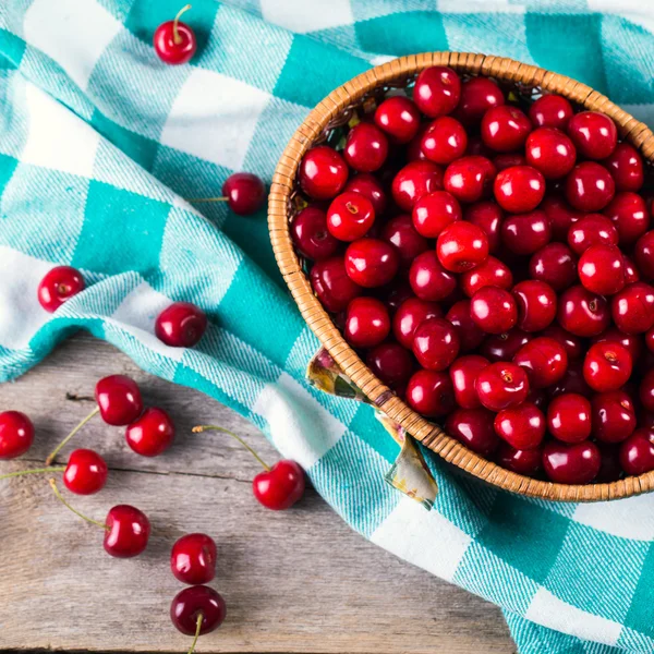 Primer plano de la cesta con cerezas frescas en el fondo de madera — Foto de Stock