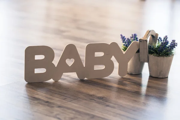 La parola bambino in lettere di legno sul pavimento con una pentola di lavanda — Foto Stock