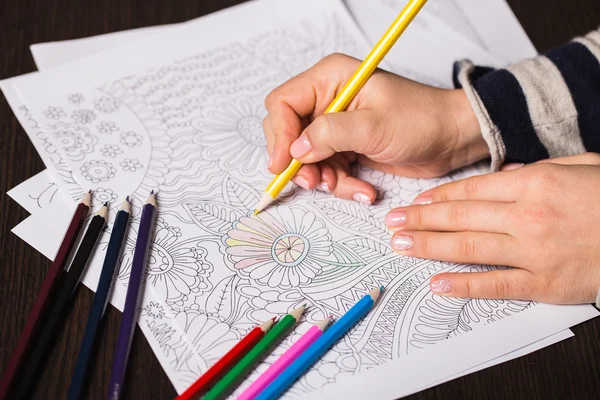 stock image Girl paints a coloring book for adults with crayons