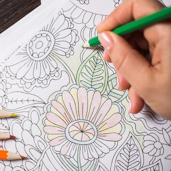 Девушка рисует раскраску для взрослых карандашами — стоковое фото