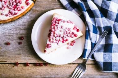 Cheesecake ile ince ahşap arka plan üzerinde taze kırmızı kuş üzümü
