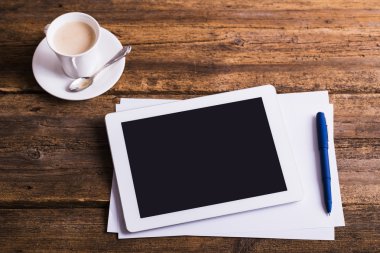 Dijital tablet ve eski ahşap zemin üzerine kahve