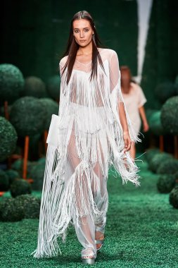 Bir model Alena Akhmadullina podyum üzerinde yürüyor