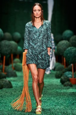 Bir model Alena Akhmadullina podyum üzerinde yürüyor