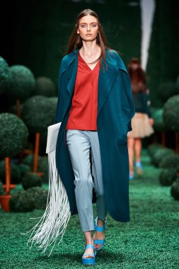 Bir model Alena Akhmadullina podyum üzerinde yürüyor