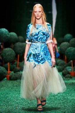 Bir model Alena Akhmadullina podyum üzerinde yürüyor