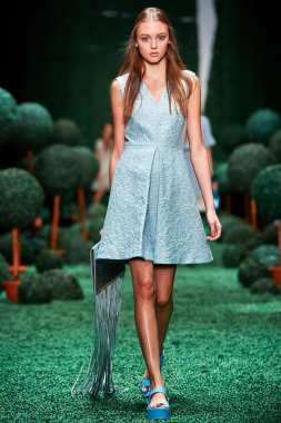 Bir model Alena Akhmadullina podyum üzerinde yürüyor