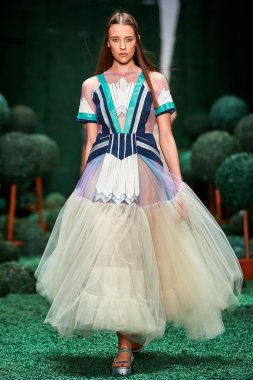 Bir model Alena Akhmadullina podyum üzerinde yürüyor