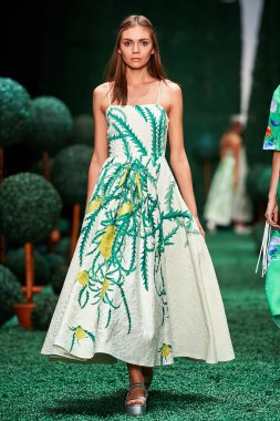 Bir model Alena Akhmadullina podyum üzerinde yürüyor