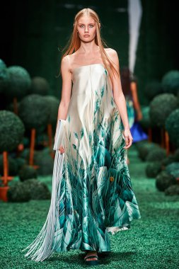 Bir model Alena Akhmadullina podyum üzerinde yürüyor