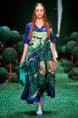 Bir model Alena Akhmadullina podyum üzerinde yürüyor