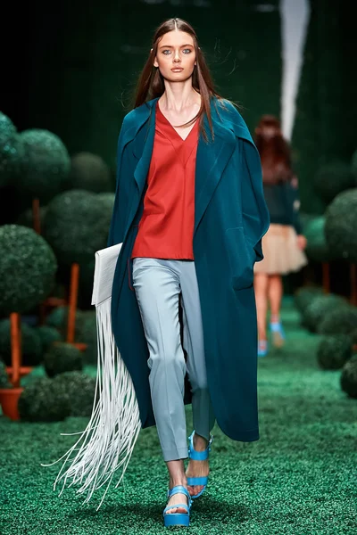 Bir model Alena Akhmadullina podyum üzerinde yürüyor