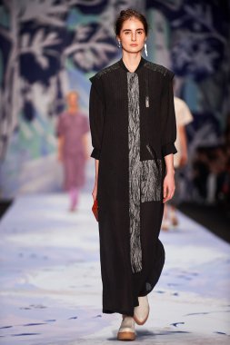 Bir model Alena Akhmadullina podyum üzerinde yürüyor