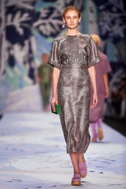 Bir model Alena Akhmadullina podyum üzerinde yürüyor