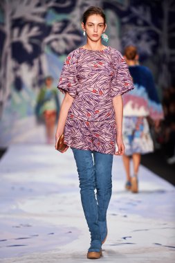 Bir model Alena Akhmadullina podyum üzerinde yürüyor