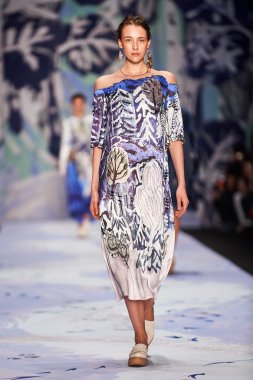 Bir model Alena Akhmadullina podyum üzerinde yürüyor