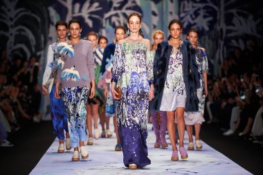 Bir model Alena Akhmadullina podyum üzerinde yürüyor