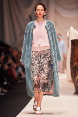 Bir model Alena Akhmadullina podyum üzerinde yürüyor