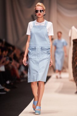 Bir model Alena Akhmadullina podyum üzerinde yürüyor