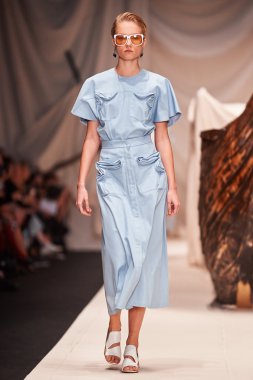 Bir model Alena Akhmadullina podyum üzerinde yürüyor