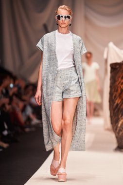 Bir model Alena Akhmadullina podyum üzerinde yürüyor