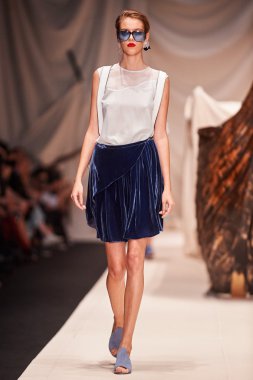 Bir model Alena Akhmadullina podyum üzerinde yürüyor