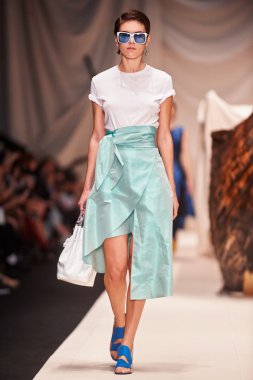 Bir model Alena Akhmadullina podyum üzerinde yürüyor