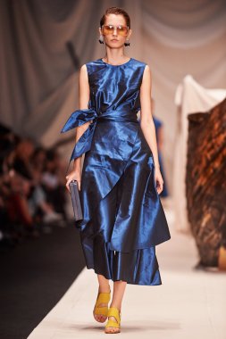 Bir model Alena Akhmadullina podyum üzerinde yürüyor