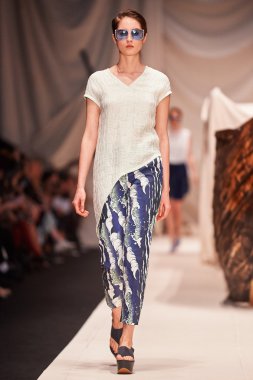 Bir model Alena Akhmadullina podyum üzerinde yürüyor