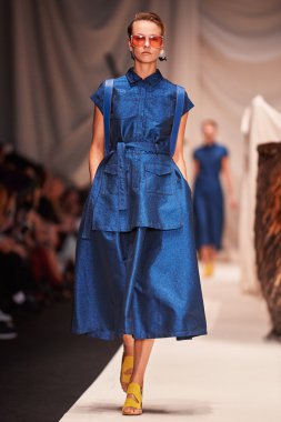 Bir model Alena Akhmadullina podyum üzerinde yürüyor