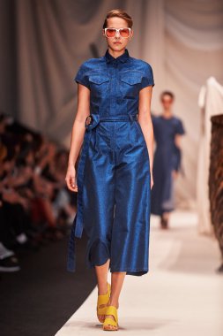 Bir model Alena Akhmadullina podyum üzerinde yürüyor