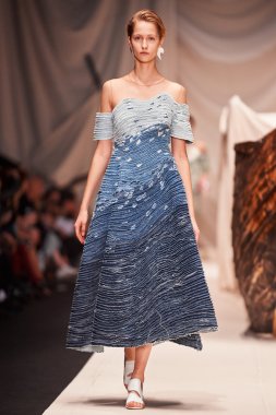 Bir model Alena Akhmadullina podyum üzerinde yürüyor