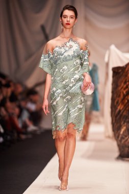 Bir model Alena Akhmadullina podyum üzerinde yürüyor