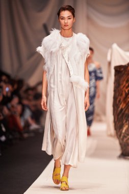 Bir model Alena Akhmadullina podyum üzerinde yürüyor