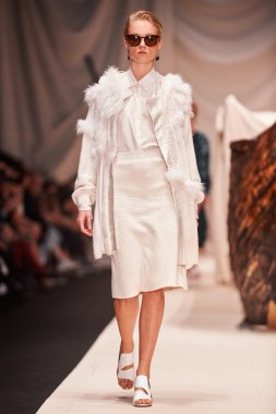 Bir model Alena Akhmadullina podyum üzerinde yürüyor