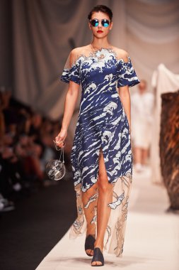 Bir model Alena Akhmadullina podyum üzerinde yürüyor