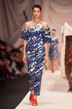 Bir model Alena Akhmadullina podyum üzerinde yürüyor