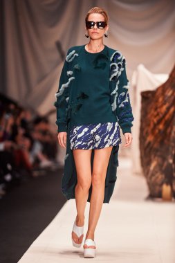 Bir model Alena Akhmadullina podyum üzerinde yürüyor