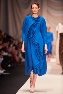 Bir model Alena Akhmadullina podyum üzerinde yürüyor