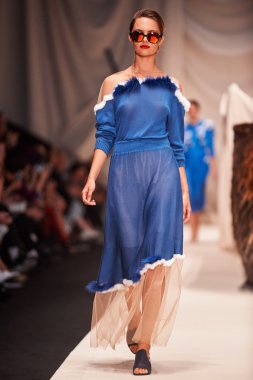 Bir model Alena Akhmadullina podyum üzerinde yürüyor