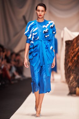 Bir model Alena Akhmadullina podyum üzerinde yürüyor