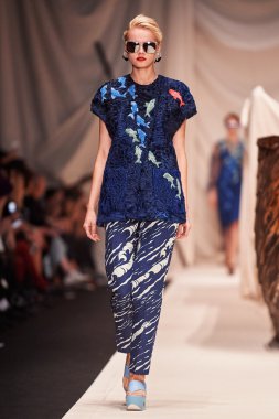 Bir model Alena Akhmadullina podyum üzerinde yürüyor