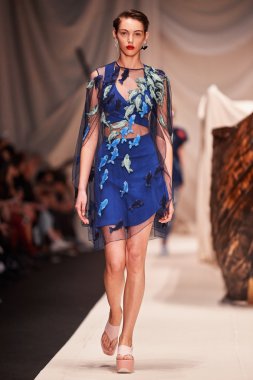 Bir model Alena Akhmadullina podyum üzerinde yürüyor