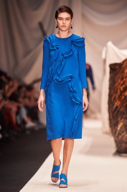 Bir model Alena Akhmadullina podyum üzerinde yürüyor