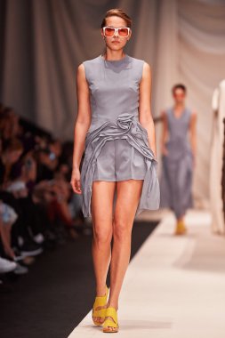 Bir model Alena Akhmadullina podyum üzerinde yürüyor